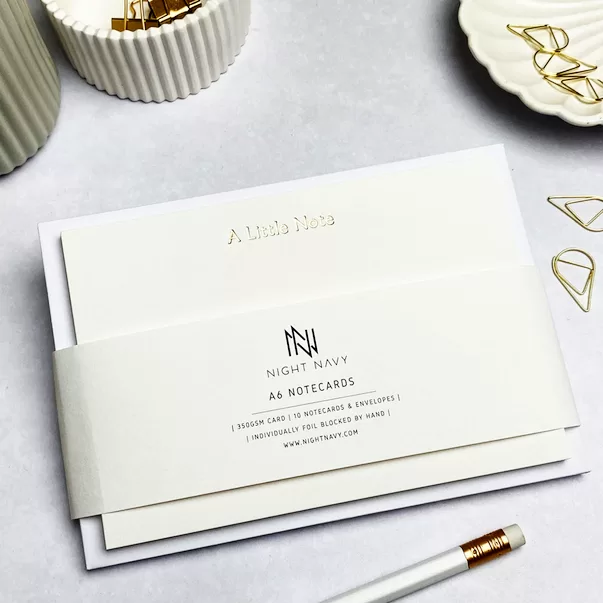 White notecard and envelope set, with A Little Note wording in gold at the top of each notecard